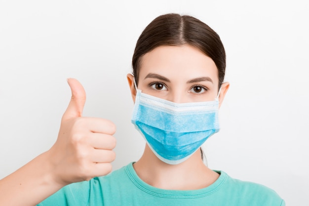 Portrait de jeune femme portant un masque médical. La personne est heureuse car elle est enfin en bonne santé. Protégez votre santé. Concept de coronavirus