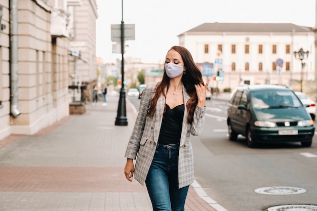 Portrait d'une jeune femme portant un masque de protection dans la rue