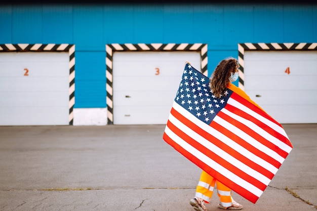 Photo portrait d'une jeune femme portant un masque et tenant un drapeau