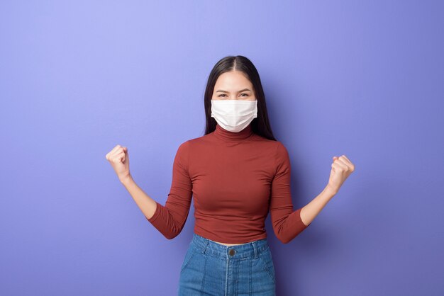 Portrait d'une jeune femme porte un masque facial sur fond violet