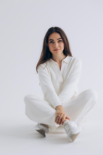 portrait d'une jeune femme posant pour une photo sur fond blanc studio lumière du jour naturelle