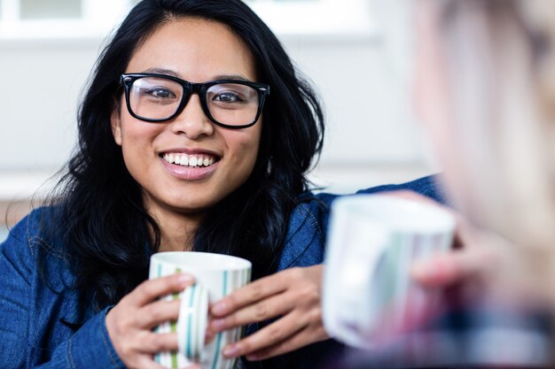 Portrait de jeune femme prenant un café avec un ami