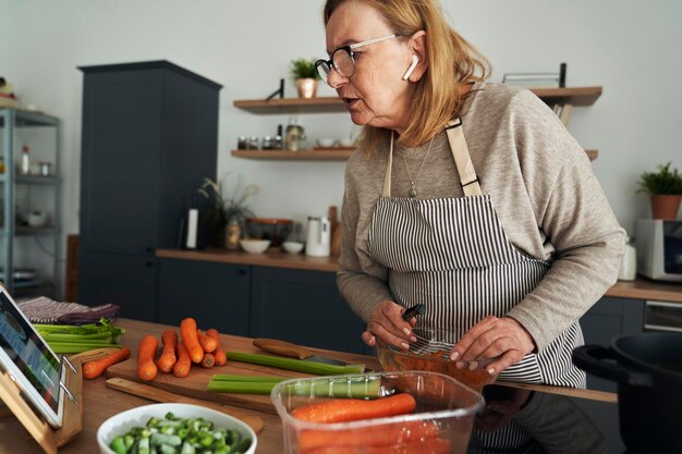 Portrait d'une jeune femme préparant de la nourriture à la maison