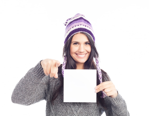 Portrait de jeune femme avec un pull et un chapeau péruvien en laine tenant une carte de signe