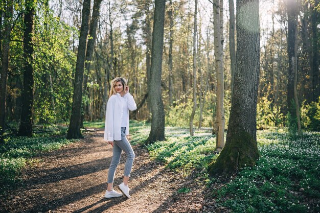 Portrait d'une jeune femme qui se promène dans la forêt de printemps