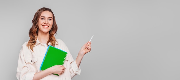 Portrait d'une jeune femme de race blanche avec un stylo et un bloc-notes notobook isolé sur fond blanc étudiant indépendant