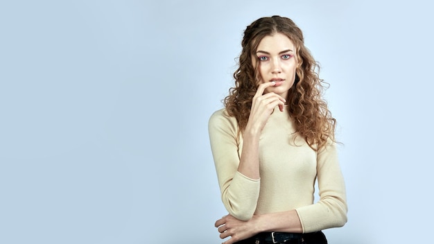 Photo portrait d'une jeune femme réfléchie aux cheveux bouclés