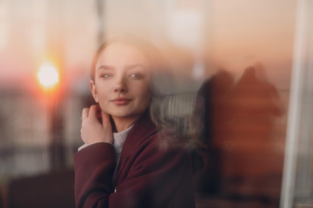 Photo portrait d'une jeune femme regardant par la fenêtre