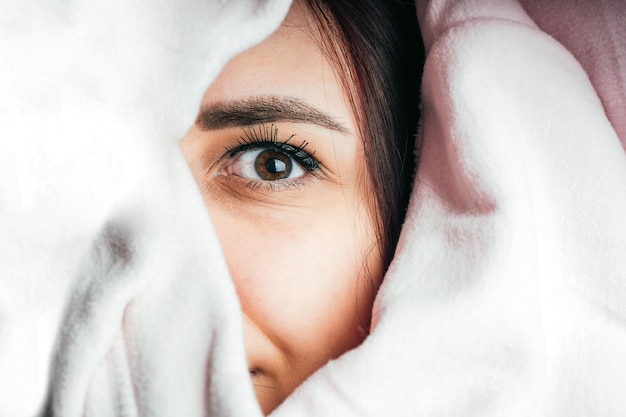 Portrait d'une jeune femme regardant par un sweat à capuche