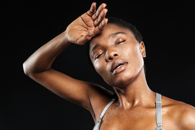 Portrait d'une jeune femme relaxante après une séance d'entraînement isolée sur le mur noir