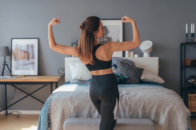 Portrait de jeune femme de remise en forme montrant les muscles