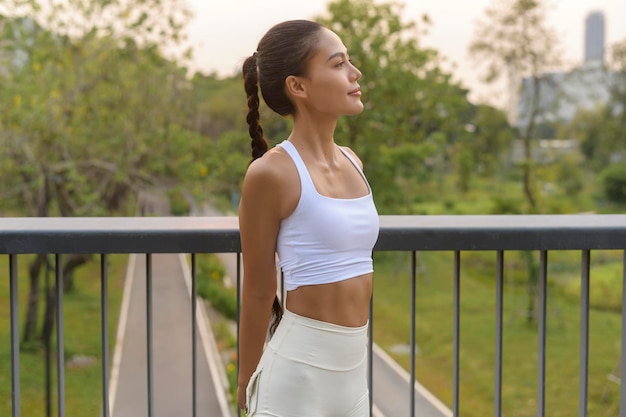 Portrait de jeune femme de remise en forme en vêtements de sport dans le parc de la ville