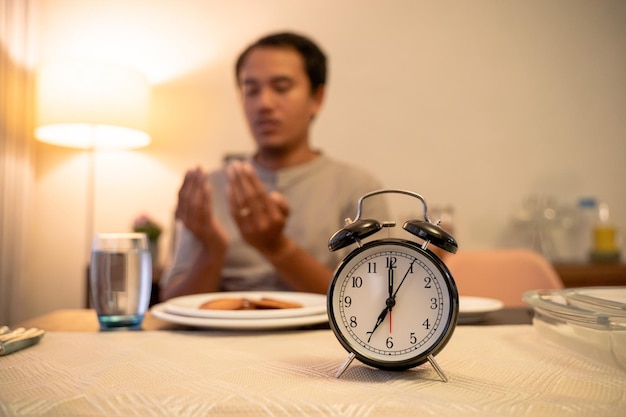 Portrait d'une jeune femme avec un réveil sur la table