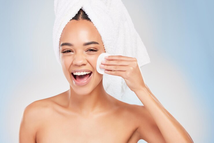 Photo portrait de jeune femme et rire avec du coton nettoyant le visage en studio arrière-plan pour les cosmétiques de soin de la peau et la beauté dermatologie de la personne féminine ou toilettage frais pour l'hygiène de bien-être et l'anti-vieillissement
