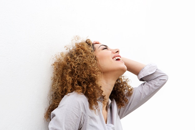 Portrait de jeune femme rire avec la main dans les cheveux