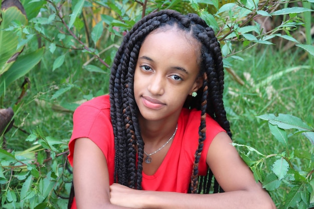 Photo portrait d'une jeune femme en rouge au milieu des plantes