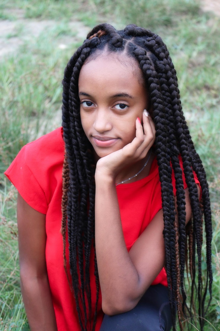 Photo portrait d'une jeune femme en rouge avec de belles tresses longues
