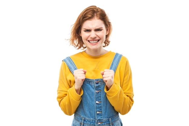 Portrait jeune femme rousse en colère criant isolé sur fond blanc studio montrant des émotions négatives