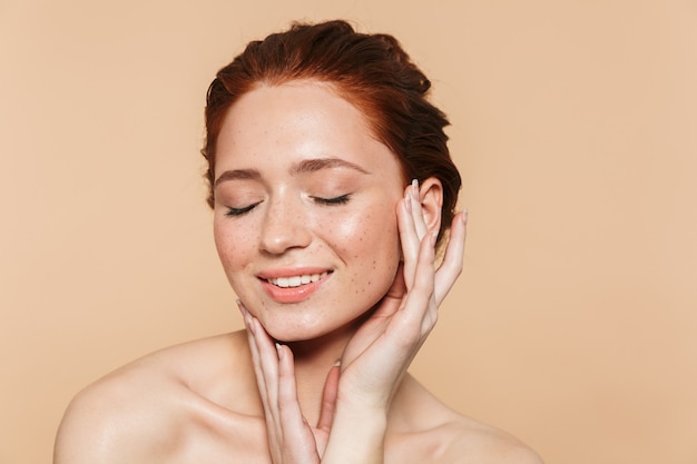 Portrait d'une jeune femme rousse incroyable souriante assez heureuse posant isolée.