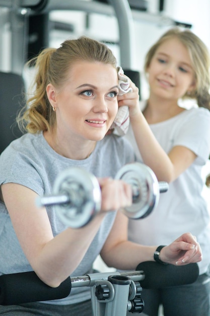 Portrait d'une jeune femme avec sa fille adolescente dans une salle de sport avec des haltères