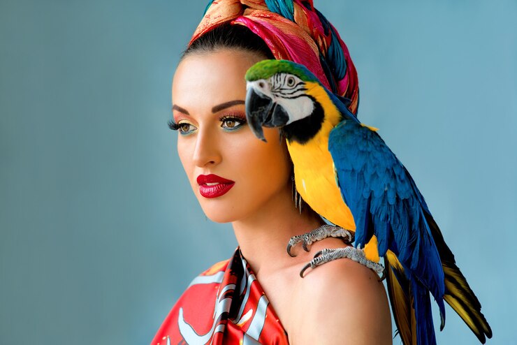 Photo portrait de jeune femme séduisante dans un style africain avec perroquet ara sur son épaule