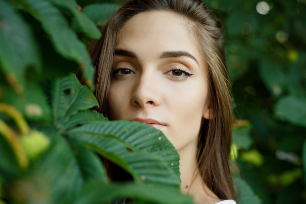 Portrait d'une jeune femme séduisante parmi les feuilles