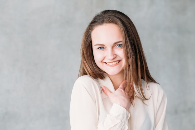 Portrait de jeune femme. Souriant et timide au compliment avec la main au cou