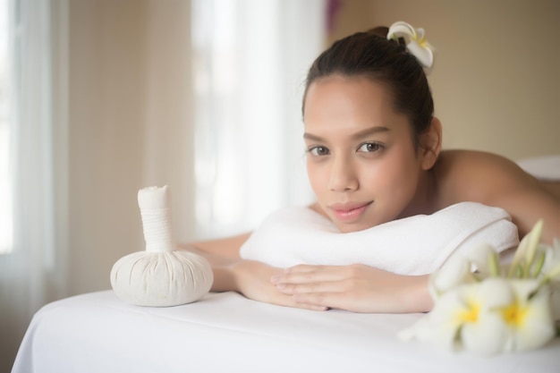 Photo portrait d'une jeune femme souriante allongée sur une table de massage dans un spa