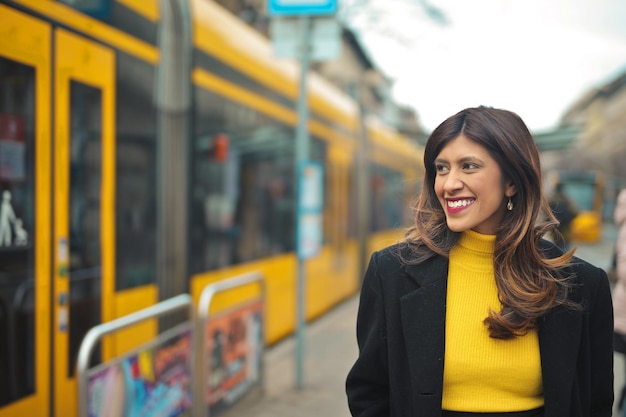 portrait de jeune femme souriante. en arrière-plan un tram