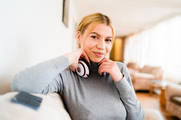 Photo portrait d'une jeune femme souriante assise sur le canapé à la maison