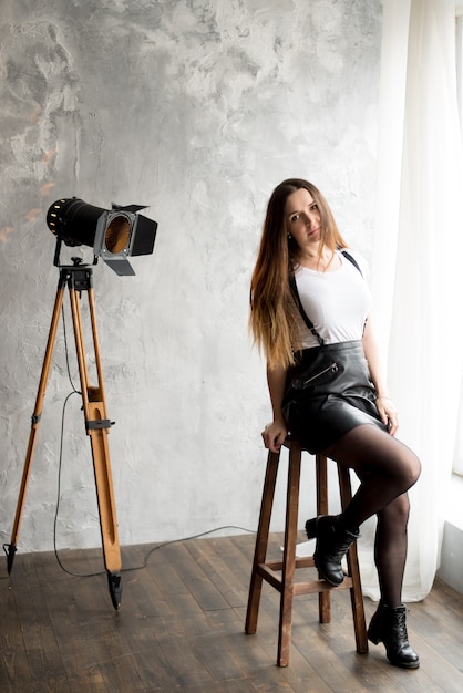 Portrait d'une jeune femme souriante assise sur une chaise