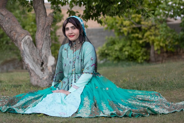 Photo portrait d'une jeune femme souriante assise à l'extérieur