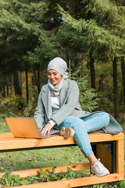 Portrait d'une jeune femme souriante assise à l'extérieur