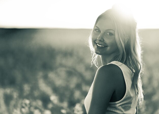 Photo portrait d'une jeune femme souriante au coucher du soleil