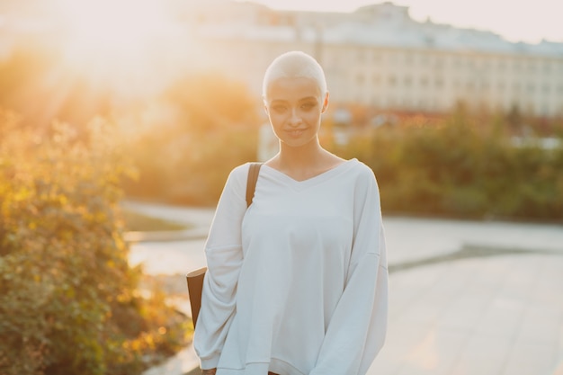 Portrait de jeune femme souriante aux cheveux courts européenne millénaire automne septembre coucher de soleil belle ha...