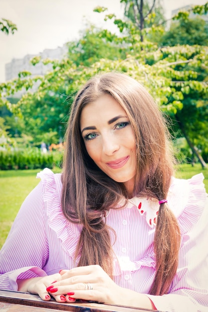 Photo portrait d'une jeune femme souriante aux cheveux roses contre les arbres