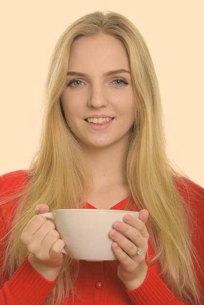 Photo portrait d'une jeune femme souriante buvant du café.