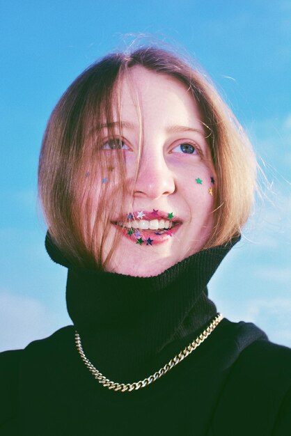 Photo portrait d'une jeune femme souriante contre le ciel bleu