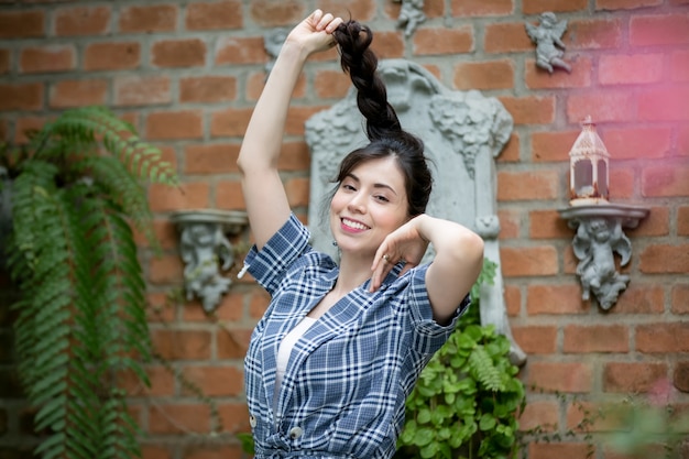 Portrait de jeune femme souriante contre jardin