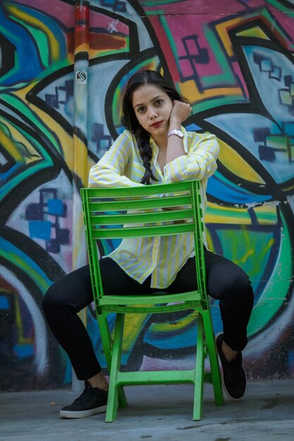 Photo portrait d'une jeune femme souriante contre un mur de graffitis