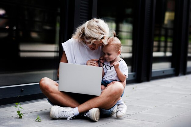 Portrait d'une jeune femme souriante créative avec un enfant à lunettes de soleil. belle fille .