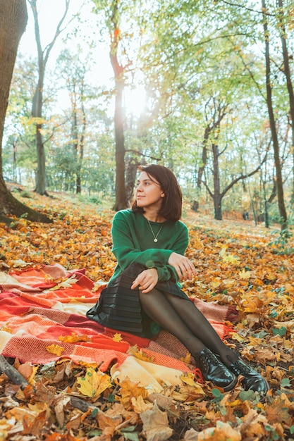 Portrait de jeune femme souriante dans le parc jaune automne. feuilles tombantes