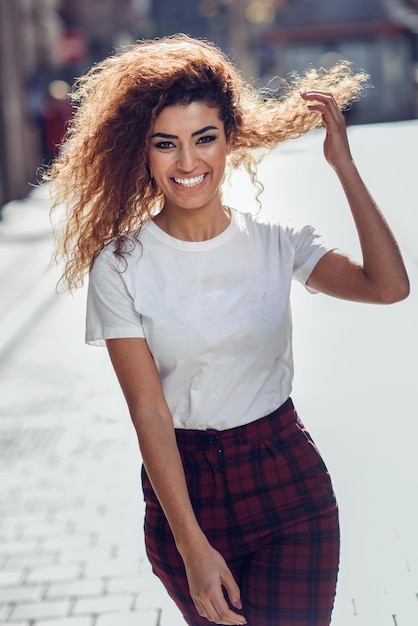 Photo portrait d'une jeune femme souriante dans la rue