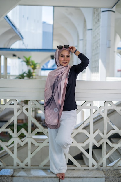 Photo portrait d'une jeune femme souriante debout contre la balustrade