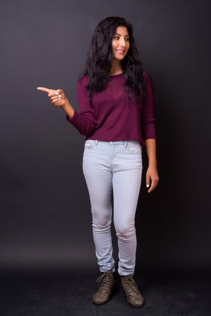 Photo portrait d'une jeune femme souriante debout contre le mur