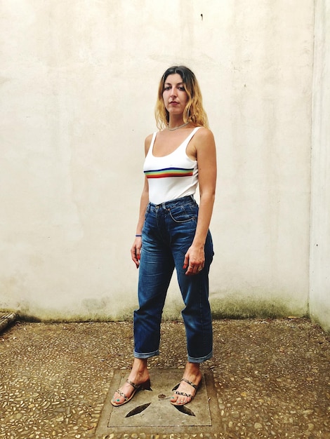 Photo portrait d'une jeune femme souriante debout contre le mur