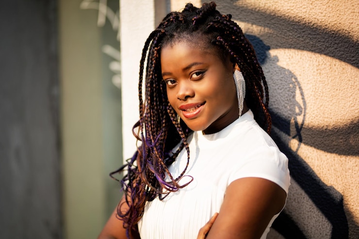 Photo portrait d'une jeune femme souriante debout contre le mur