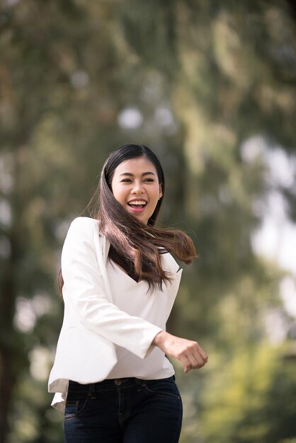 Portrait d'une jeune femme souriante debout à l'extérieur