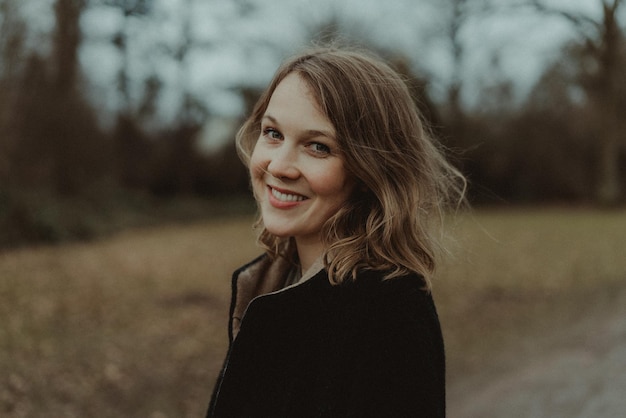 Portrait d'une jeune femme souriante debout à l'extérieur