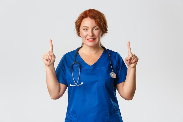 Portrait d'une jeune femme souriante debout sur un fond blanc